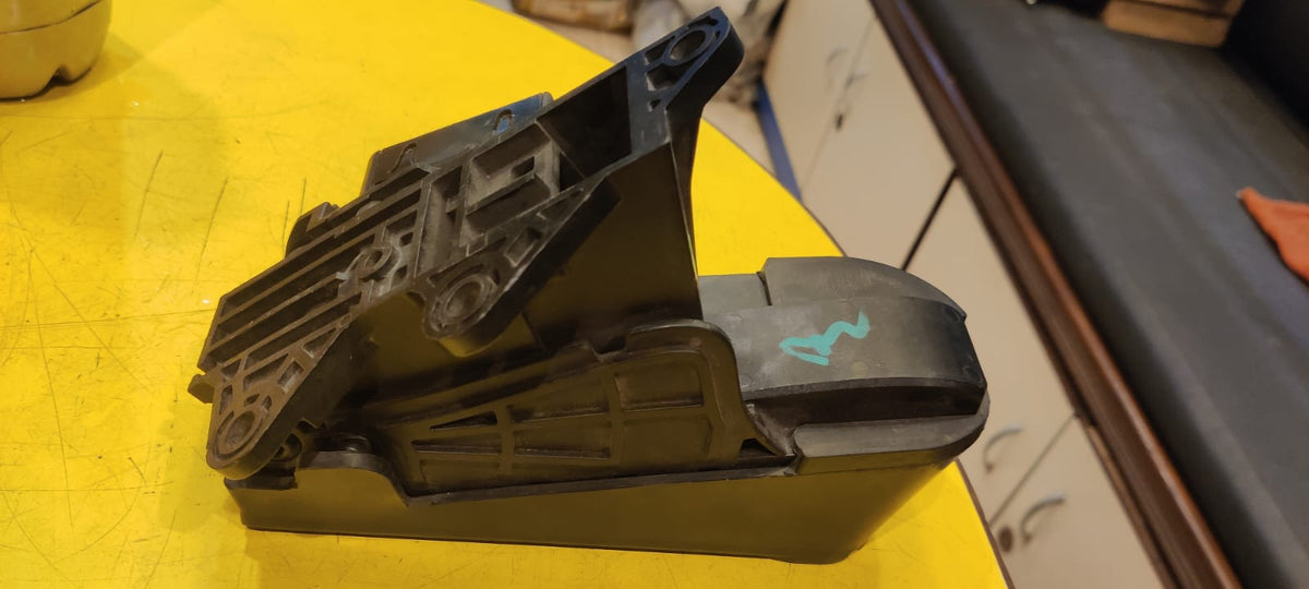 Black plastic component on a yellow surface with blurred background