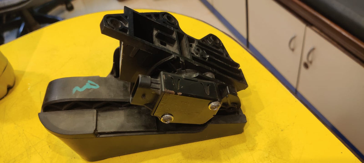 Black mechanical component on a yellow surface