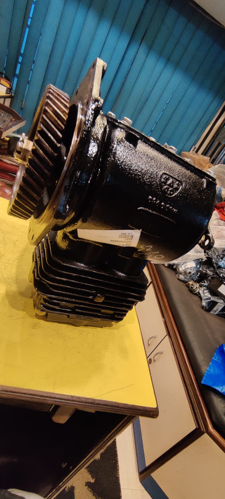 Mechanical engine block on a yellow surface with a blue wall in the background