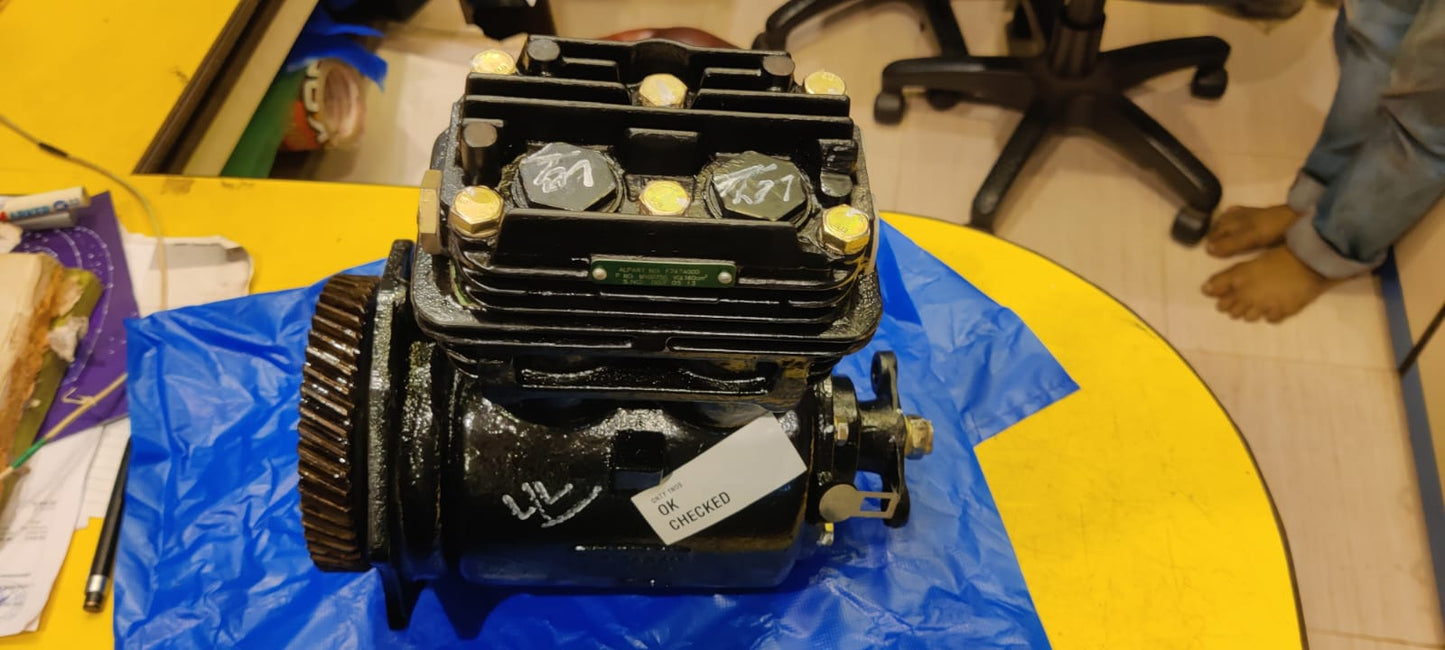 Mechanical engine block on a blue tarp with a yellow floor and office chair in the background