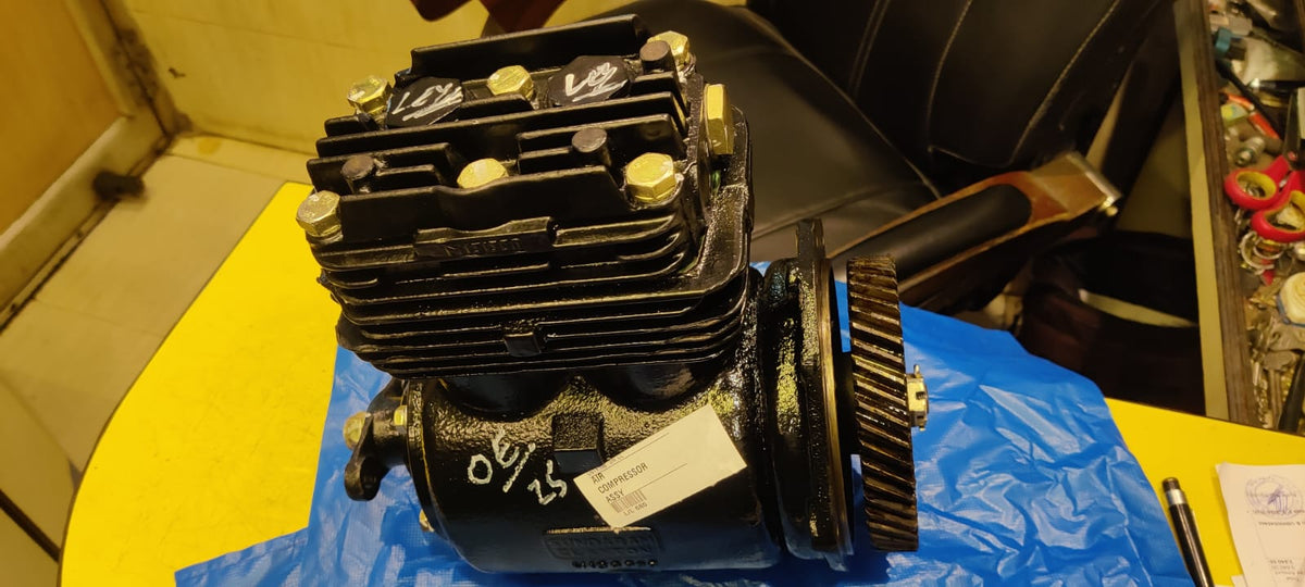 Engine block on a blue surface with tools in the background