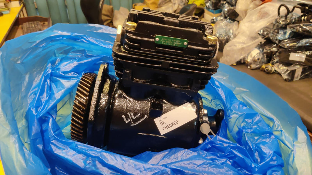 Mechanical component on a blue plastic sheet with various items in the background