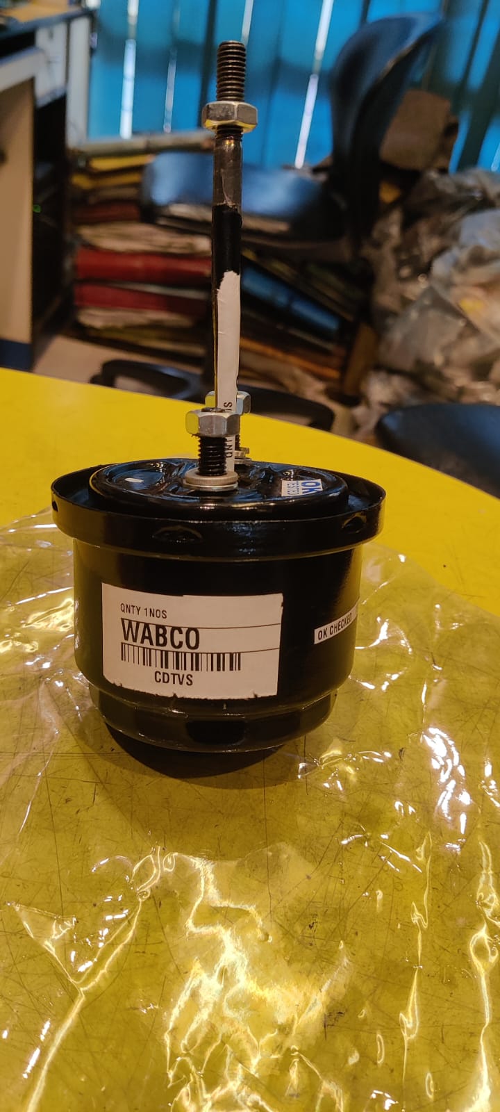 WABCO filter on a yellow surface with a blue wall in the background