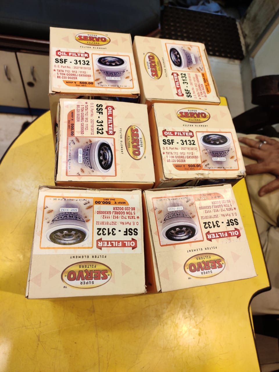 Multiple boxes of OASIS brand products on a yellow surface.