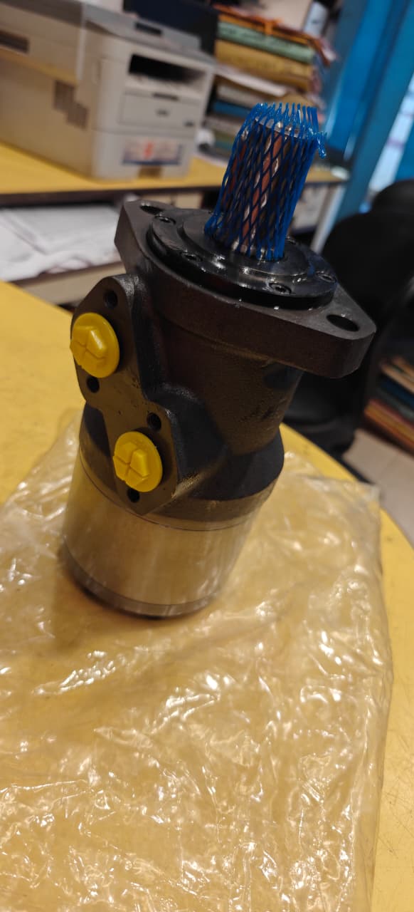 Mechanical component with blue and red wiring on a yellow surface