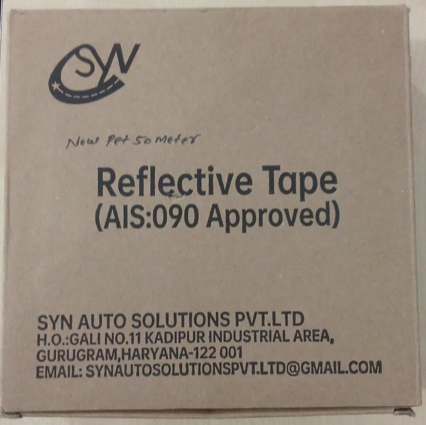 Cardboard box with reflective tape product details and SYN Auto Solutions Pvt. Ltd branding.