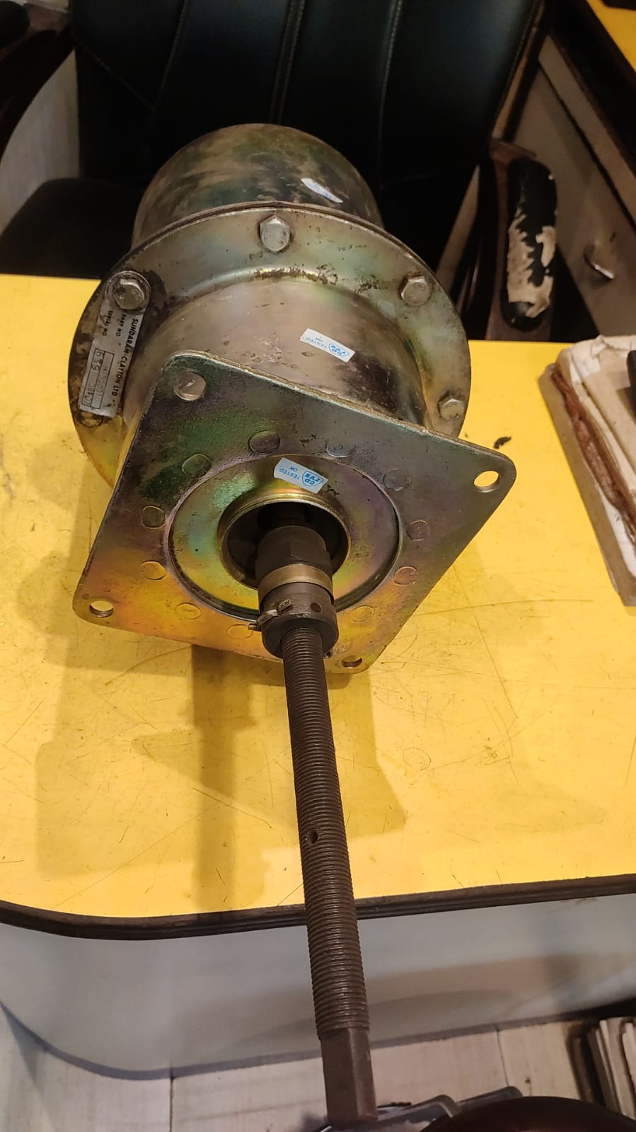 Mechanical component on a yellow surface with a blurred background