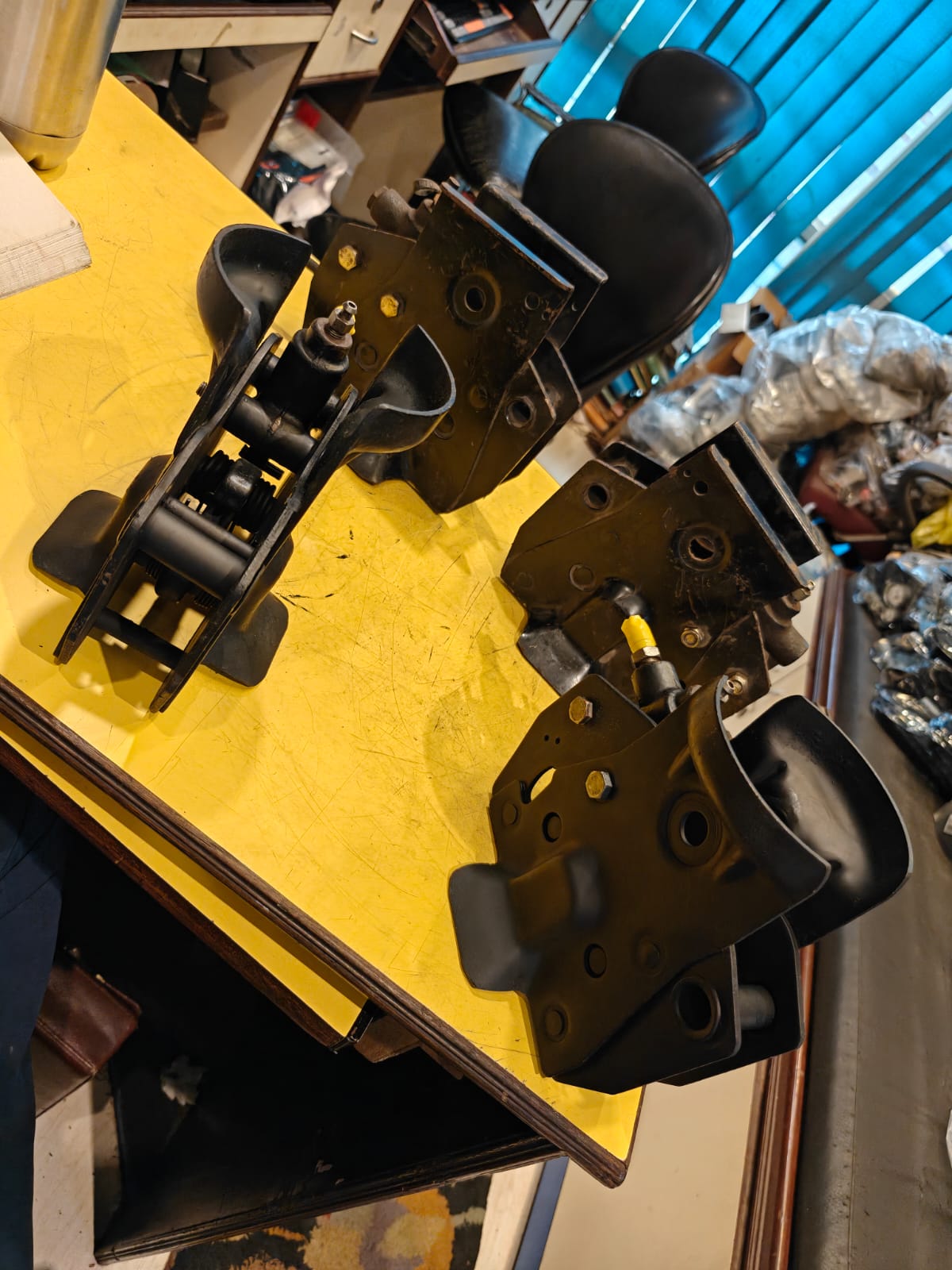 Mechanical parts on a yellow surface with a cluttered background