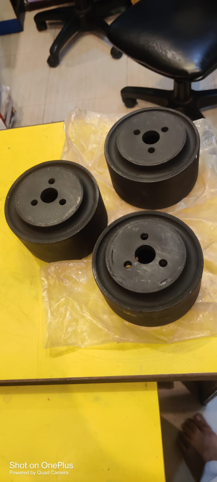 Three black cylindrical objects on a yellow surface with a blurred background