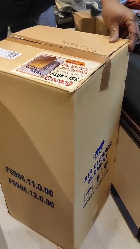 Cardboard box with shipping labels and a hand touching it