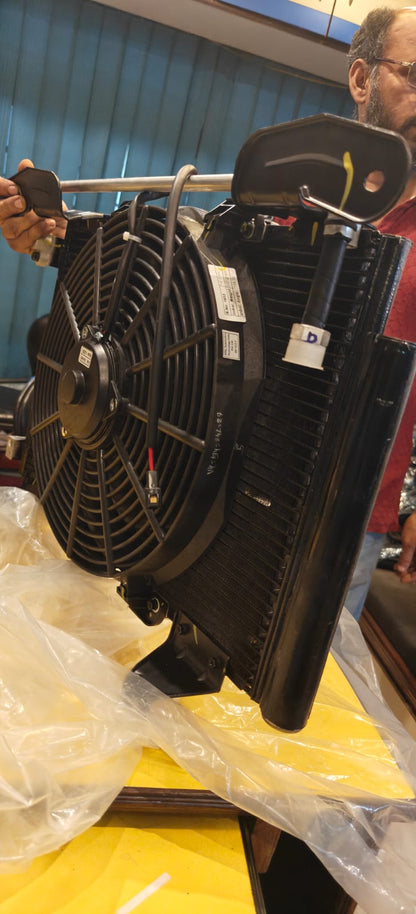 Mechanic working on a car engine with a fan assembly.