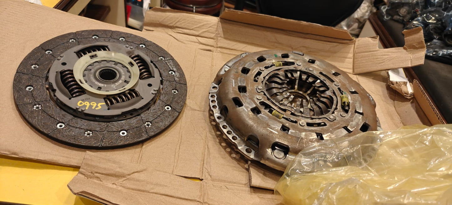 Two clutch discs on a cardboard surface with a plastic bag partially covering them.