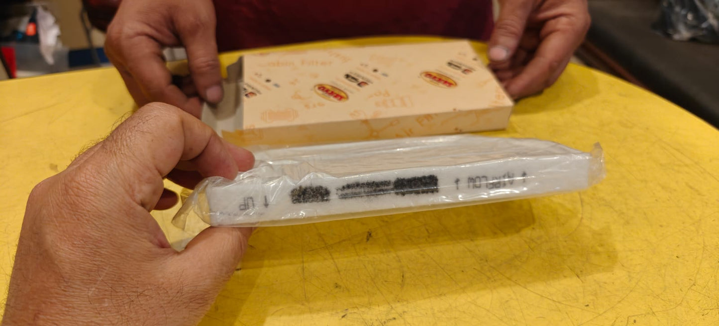 Person holding a syringe in a clear plastic package on a yellow surface