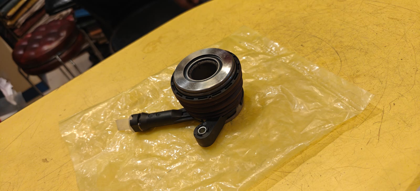 Release Bearing Mechanical component on a yellow surface with clear plastic wrap