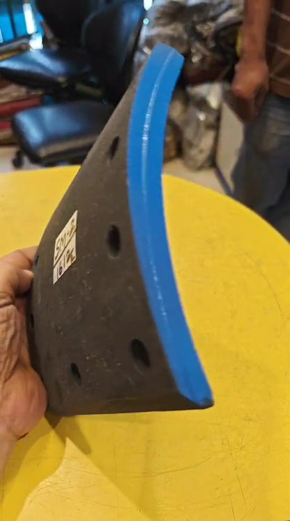 Black and blue object held by a hand on a yellow surface