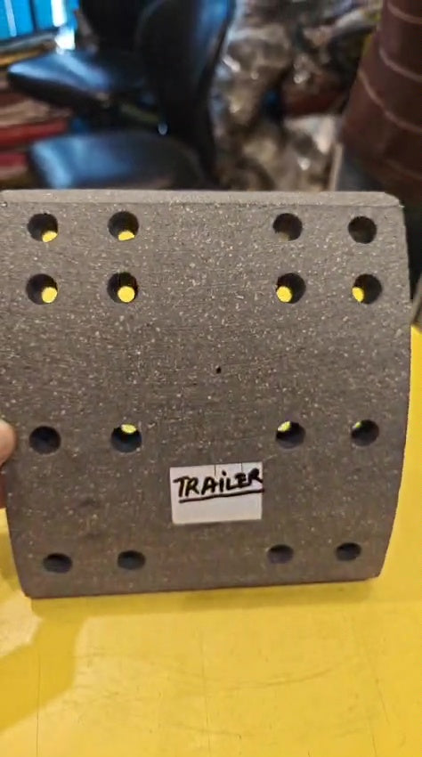 Block with holes and a 'Trailer' label on a yellow surface