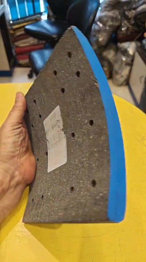 Hand holding a sanding block with blue背面和灰色砂纸面