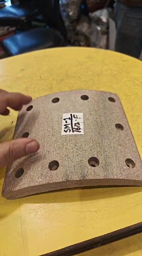 Brake pad with a label on a yellow surface