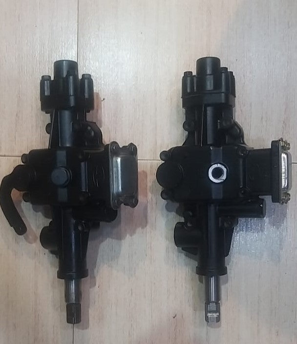 Two black mechanical components on a light wooden surface