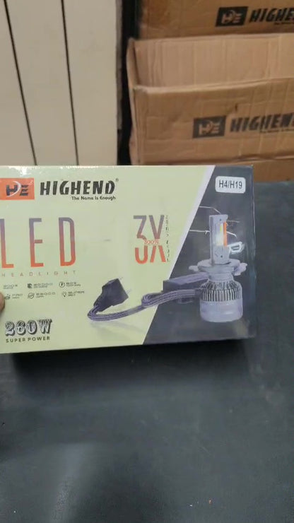 HighEnd LED car bulb packaging on a dark surface with cardboard boxes in the background.