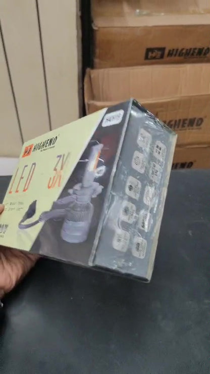 Box of LED 5K bulbs held by a hand with cardboard boxes in the background