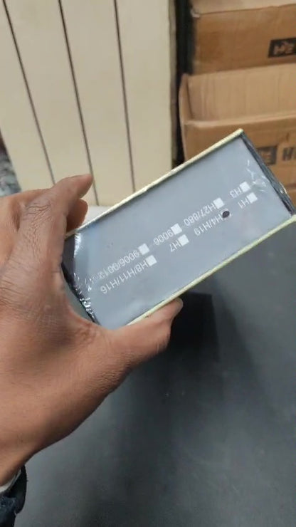 Hand holding a smartphone with a blurred screen in an indoor setting