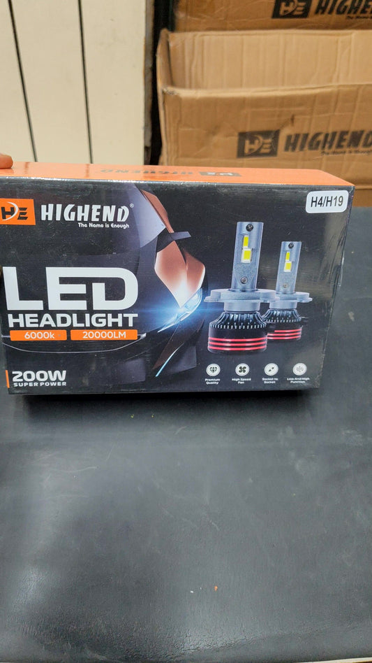 Box of HighEnd LED Headlight on a black surface with cardboard boxes in the background