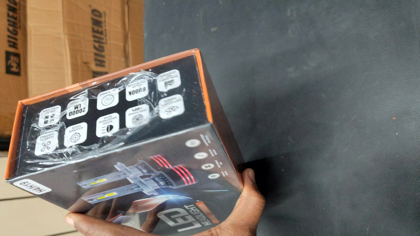 Hand holding a box with technical graphics on a dark surface