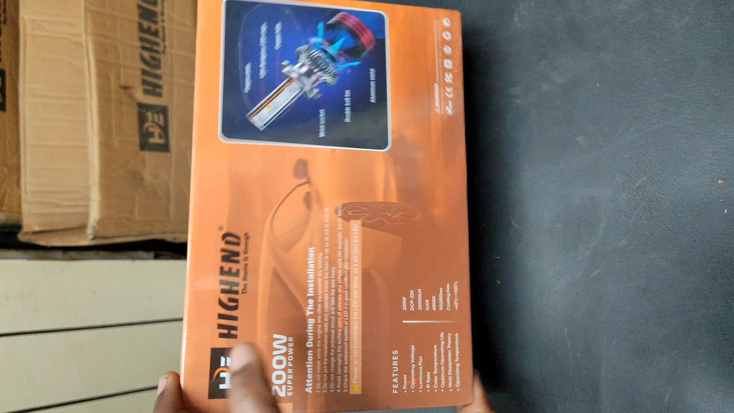 Orange box with a tool on it, held by a hand against a dark background