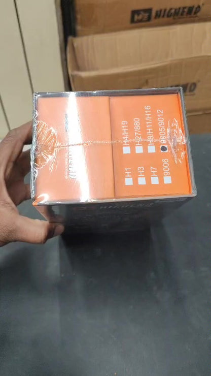 Packaged product with reflective surface held by a hand on a gray surface