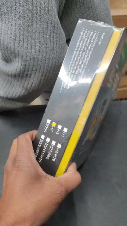 Person holding a box with text and graphics on a gray surface