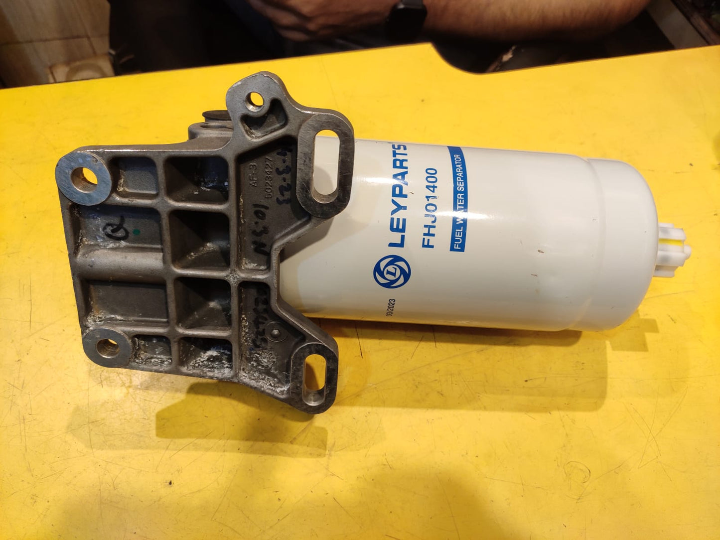 Mechanical part and Leylparis filter on a yellow surface