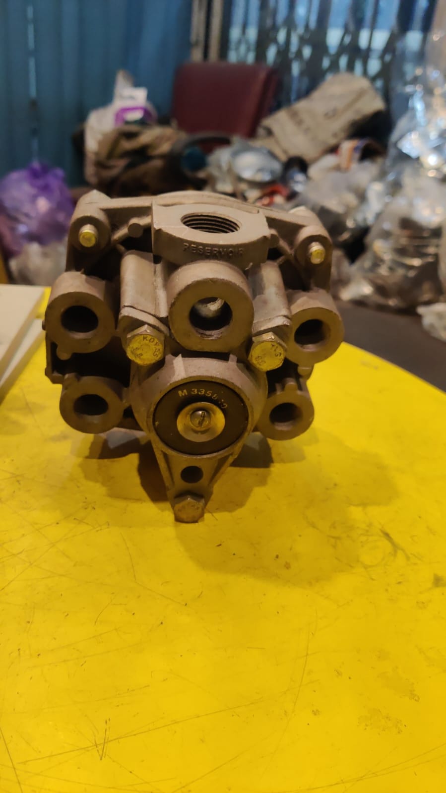 Mechanical component on a yellow surface with a cluttered background