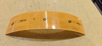 Yellow Reflective tape with brand logo on a textured surface