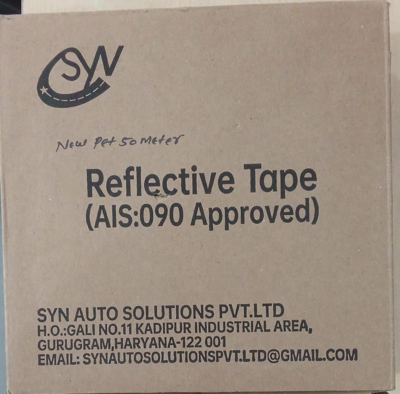 Cardboard box with reflective tape packaging and SYN AUTO SOLUTIONS PVT.LTD branding.