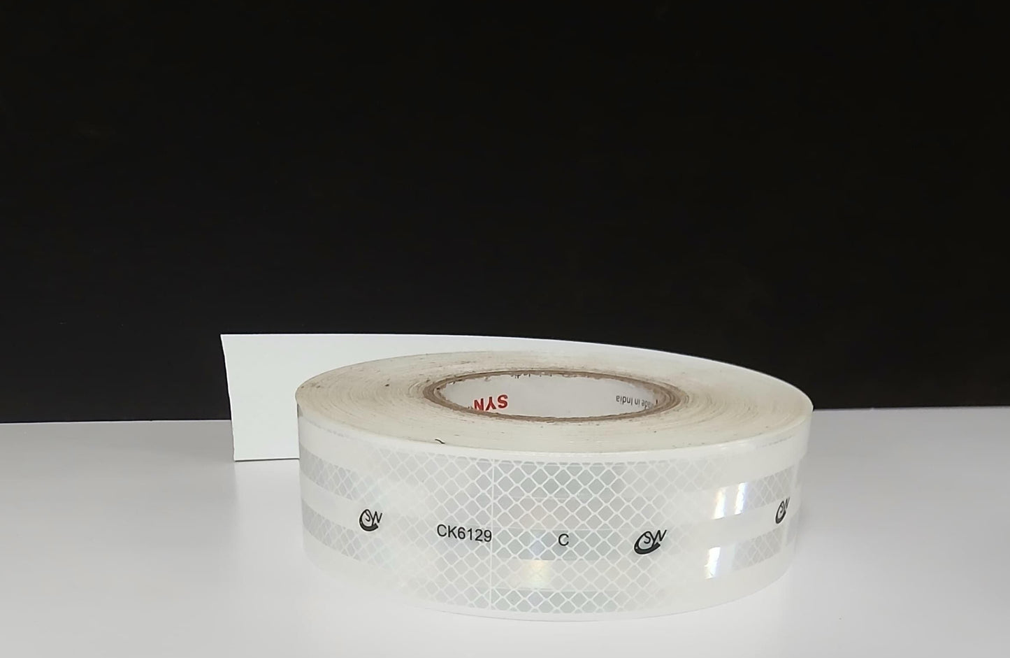 Roll of clear tape on a white surface with a black background