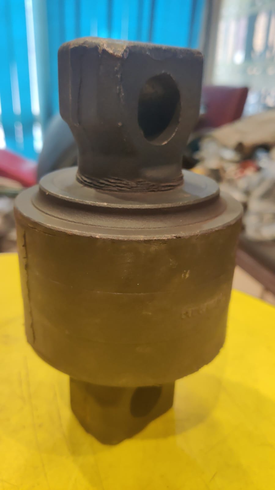 Metal component on a yellow surface with a blurred background