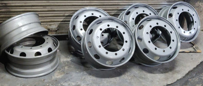Set of metallic truck rims on a concrete surface