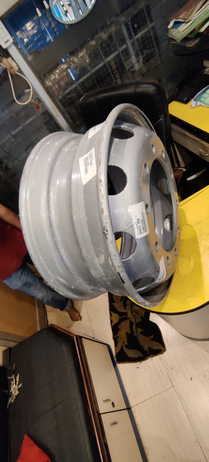 Metallic car rim on a yellow surface with a blurred background