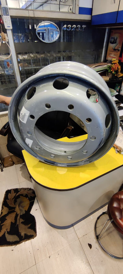 Close-up of a large metal wheel or hub on a yellow stand in an indoor setting.