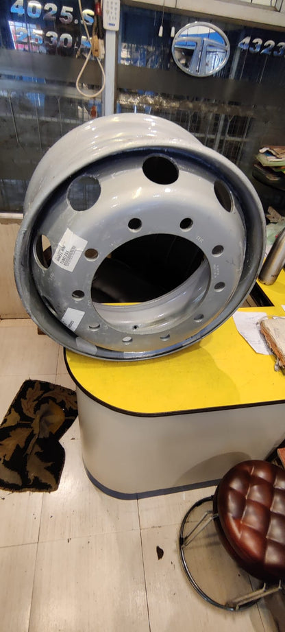 Close-up of a car wheel rim on a yellow stand with a blurred background