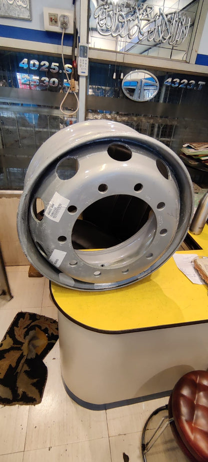 Metallic wheel hub on a yellow stand in a garage setting