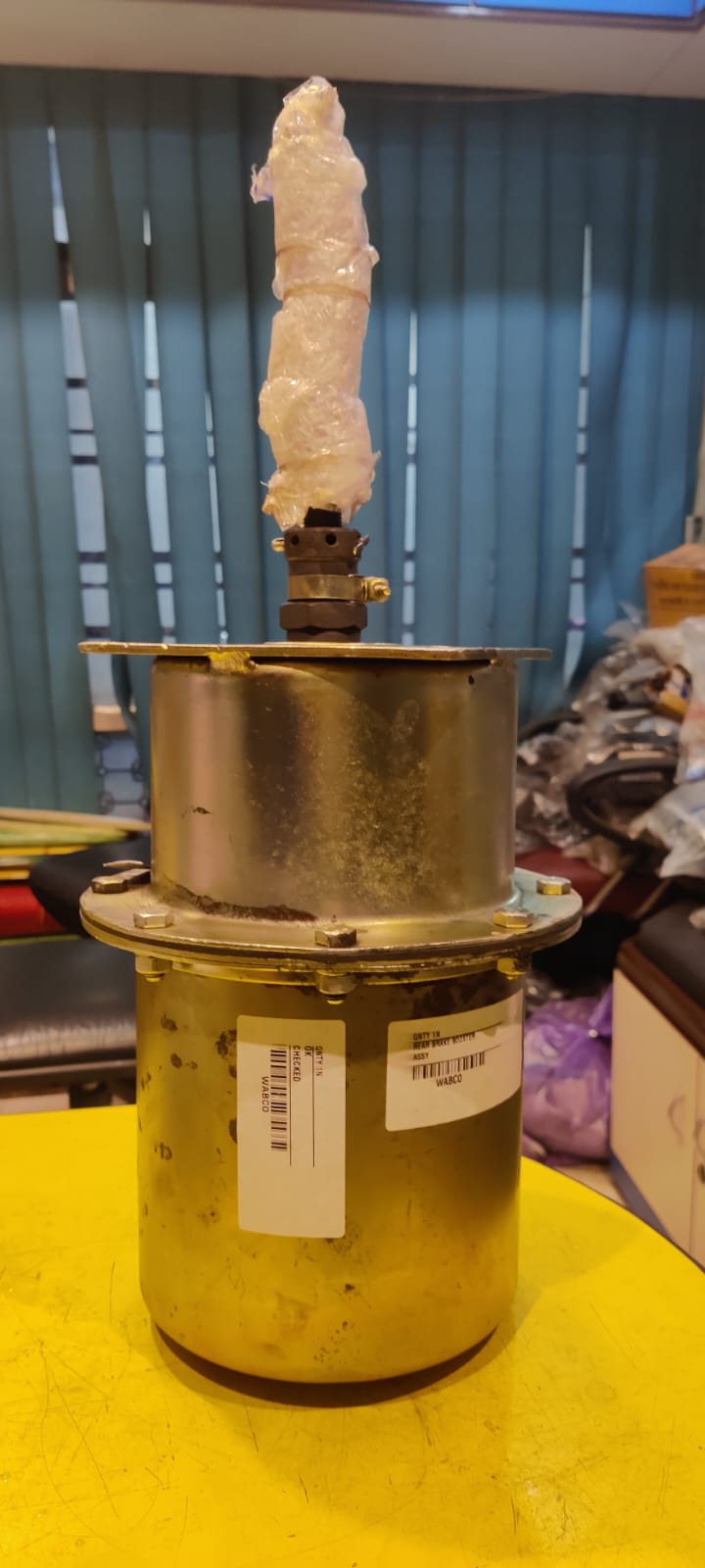 Metallic cylindrical object with a label on a yellow surface