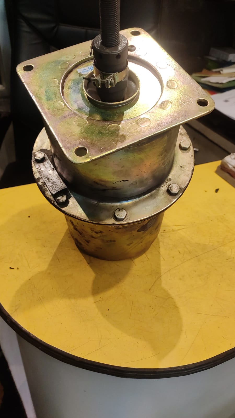 Metal mechanical component on a yellow surface