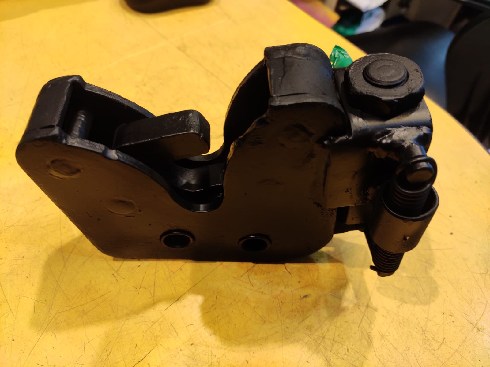 Black mechanical component on a yellow surface