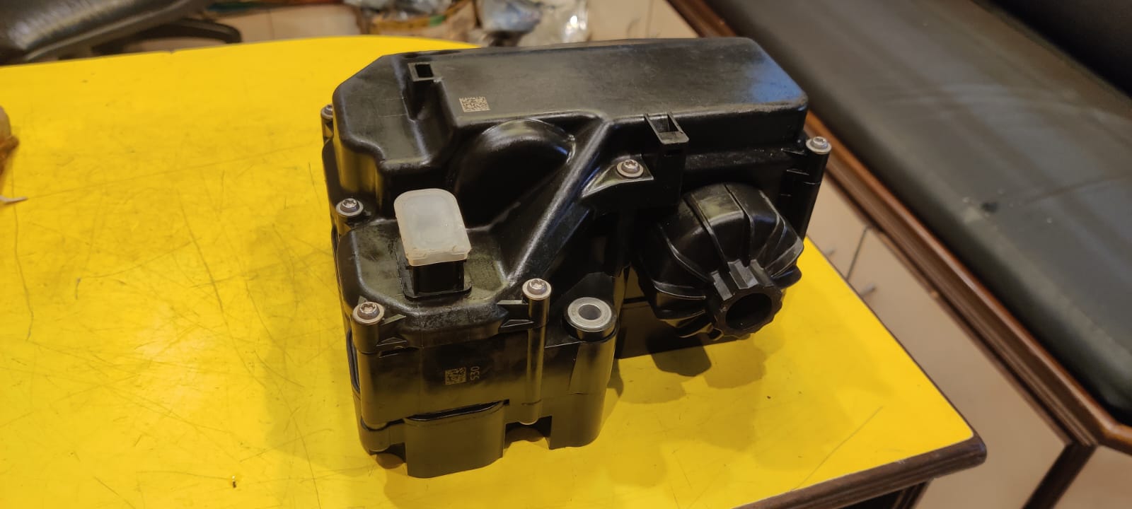 Black mechanical component on a yellow surface