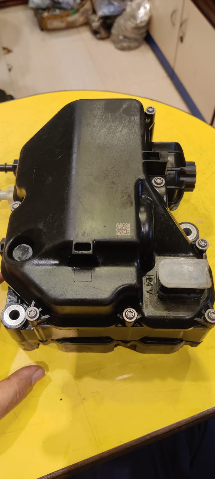 Mechanical component on a yellow surface with a blurred background