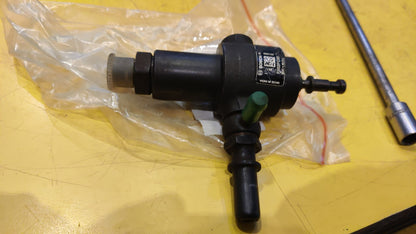 Mechanical component on a yellow surface with a clear plastic bag.
