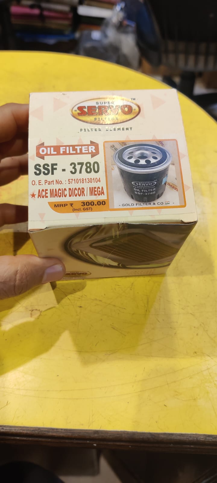 Boxed oil filter with visible branding on a yellow surface