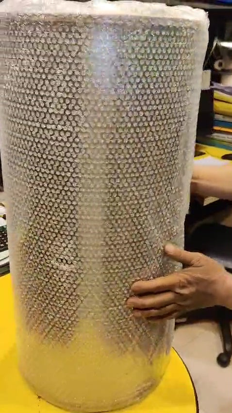 Cylindrical honeycomb-like object on a yellow surface with a blurred background